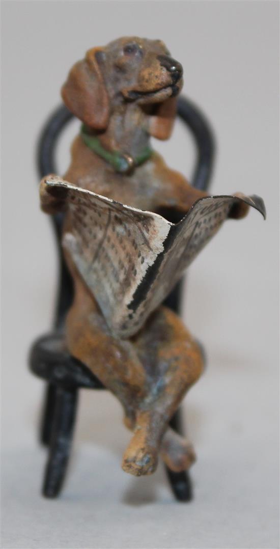 A miniature cold painted bronze model of a seated Dachshund reading a newspaper, in the manner of Franz Bergman, 2in.